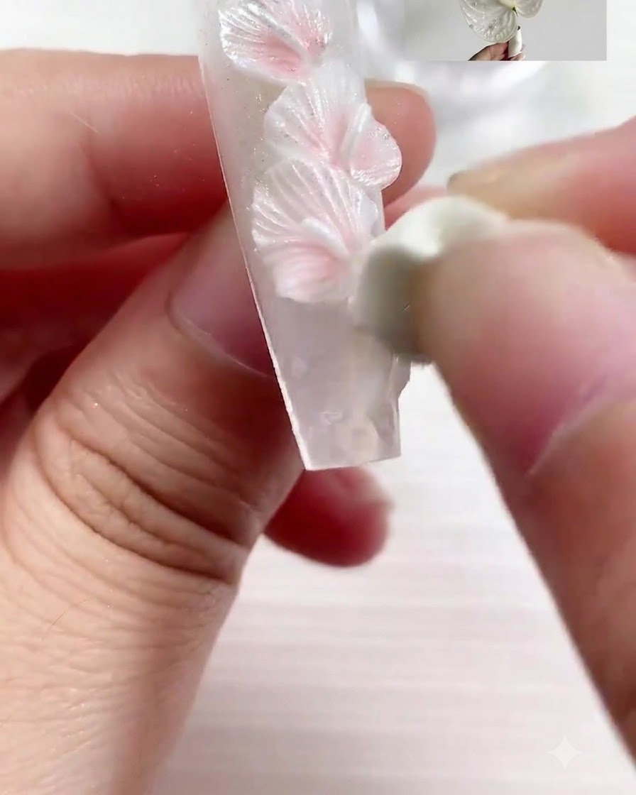 A sculpting tool pressing realistic vein lines into the sculpted petal.