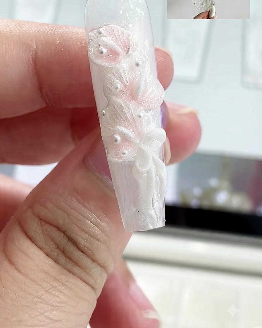 A close-up view of sculpting gel rolled into a thin strip and flattened onto a fingernail.