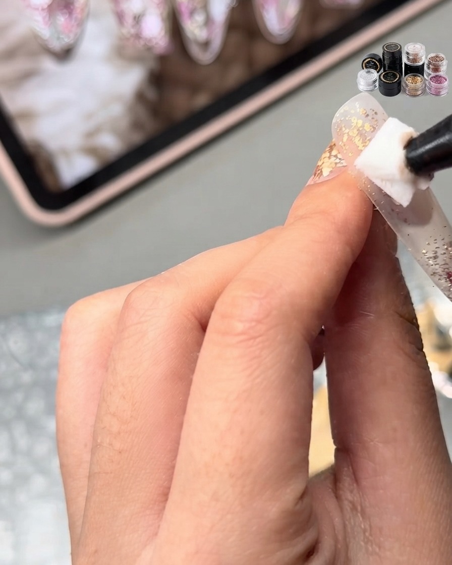 A sponge or applicator patting nude base gel onto the surface of the nail.