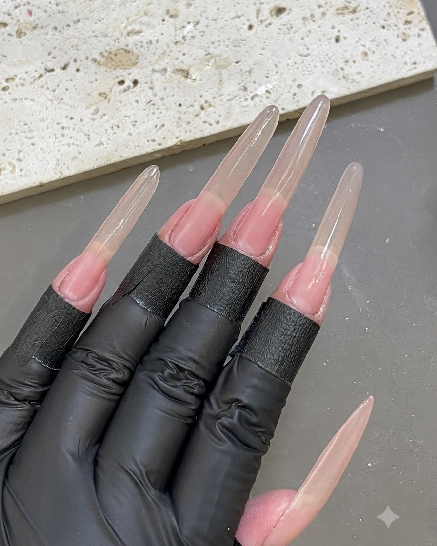 An overhead view of a hand with identical nail extension forms applied across all fingers.