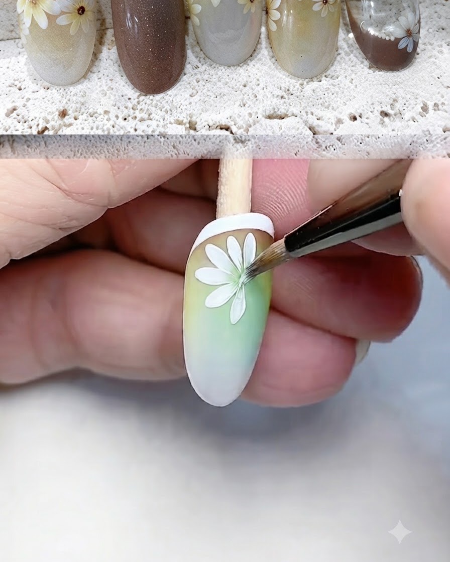 A fine liner brush carefully painting and defining white daisy petals on a gradient nail tip.