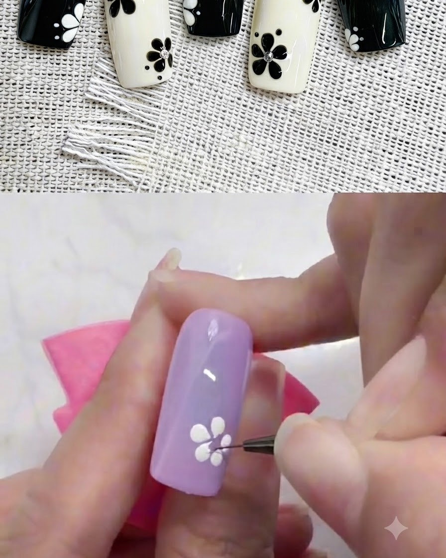 A liner brush carefully adjusting the base of a white flower petal on a colored nail.