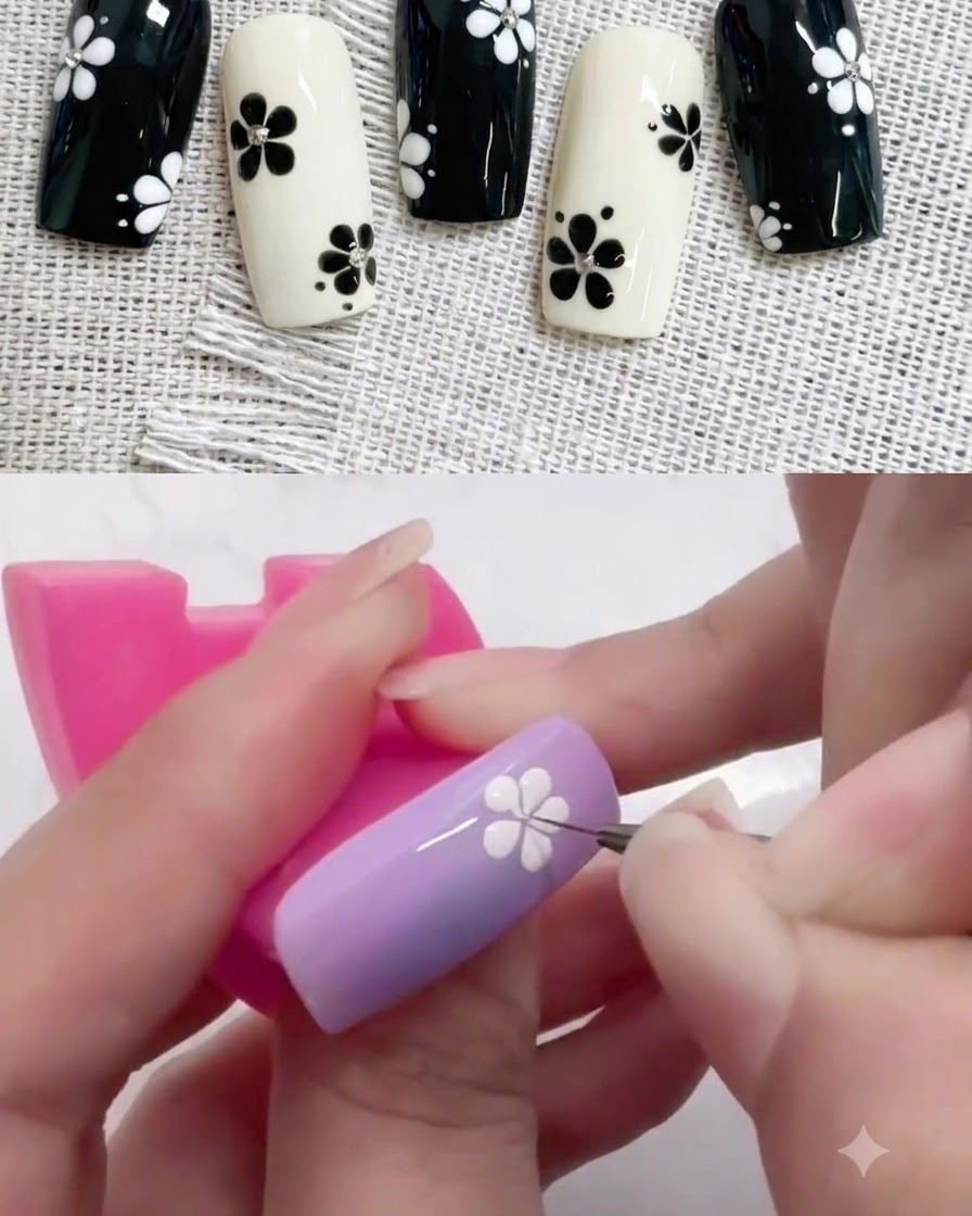 A small dotting tool placing a black center dot into a white flower design on a purple nail.