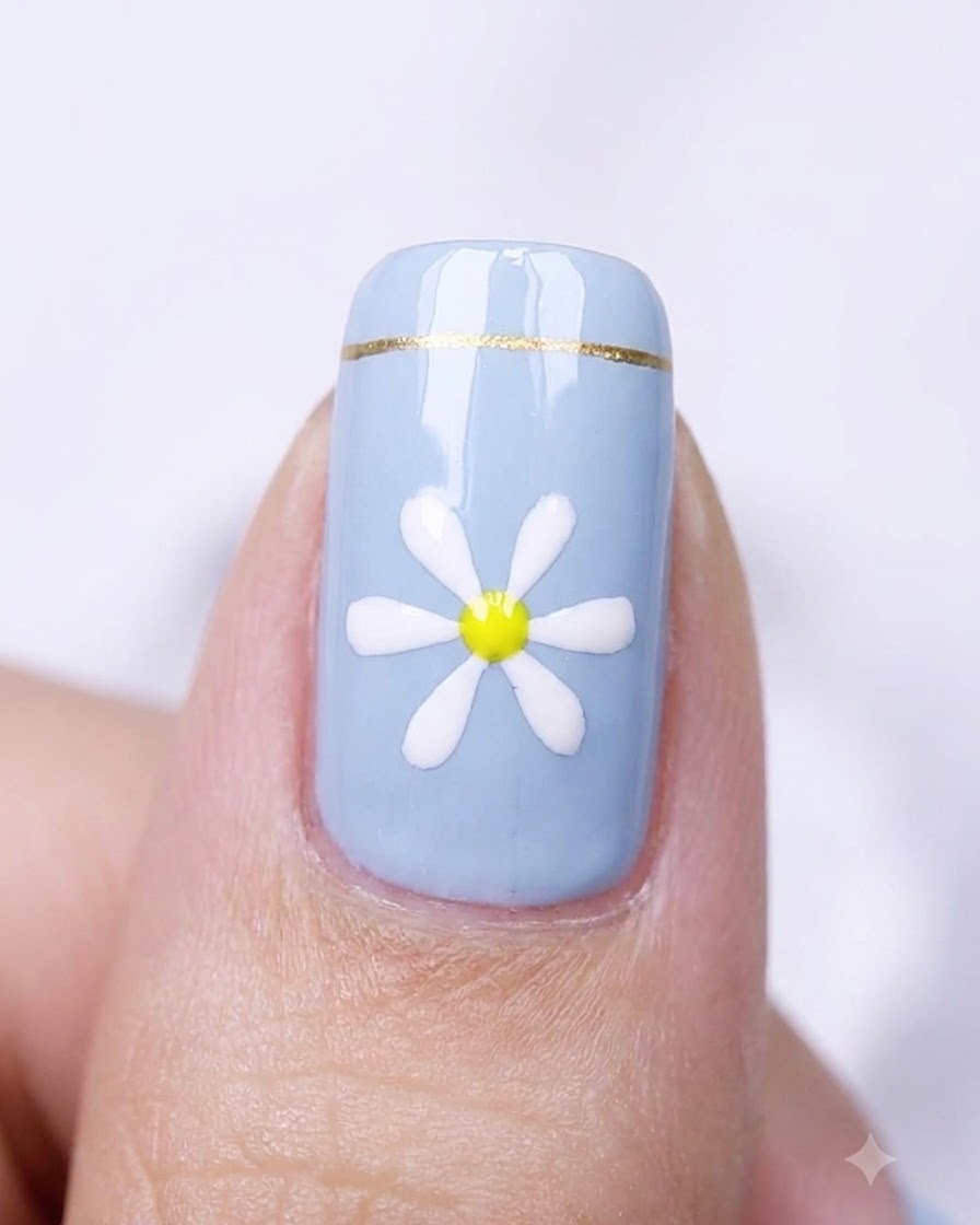 A close-up of a blue nail with a daisy design placed inside a nail curing lamp.