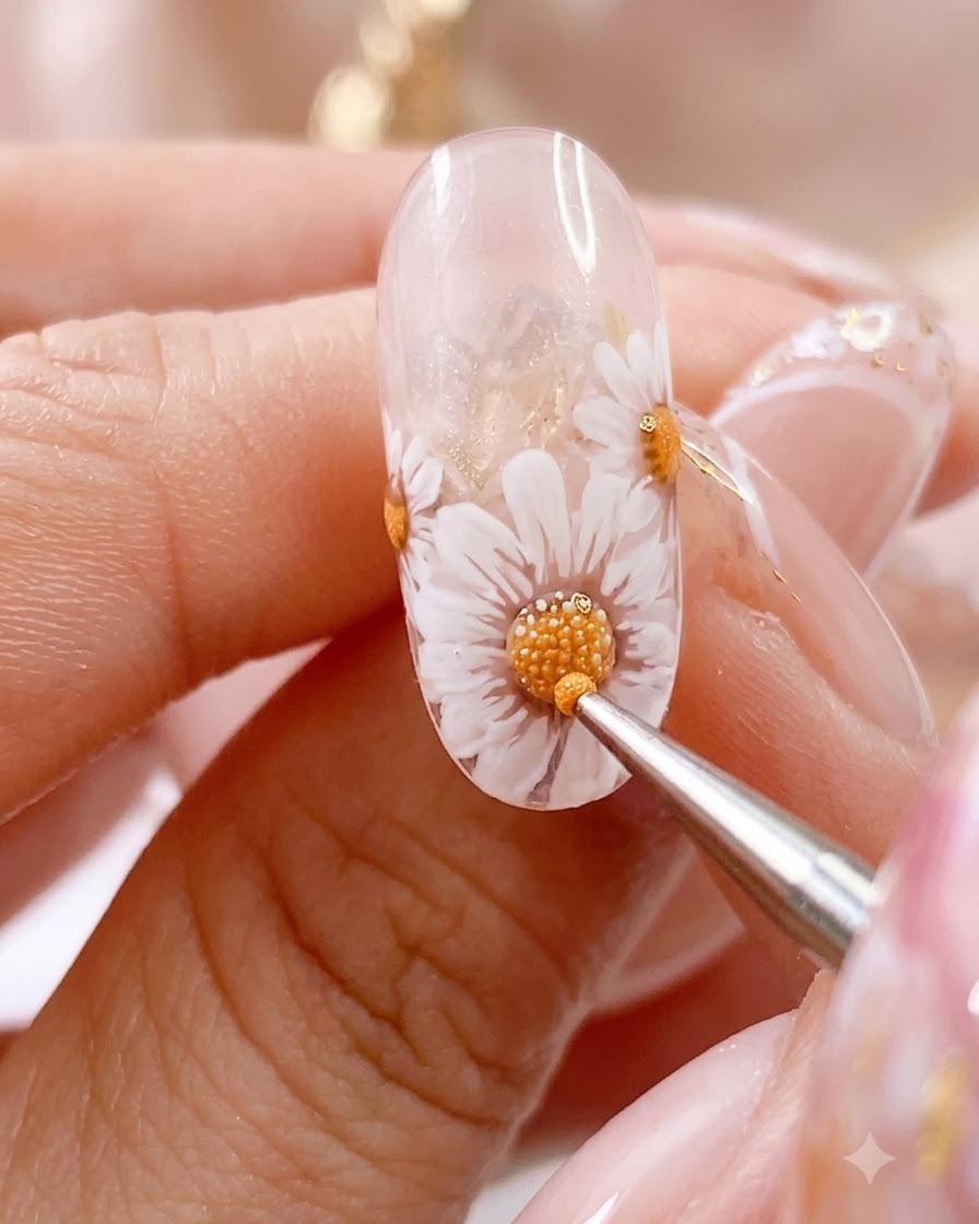 A detailing brush working on a cured nail featuring a daisy with intricate dotted accents.