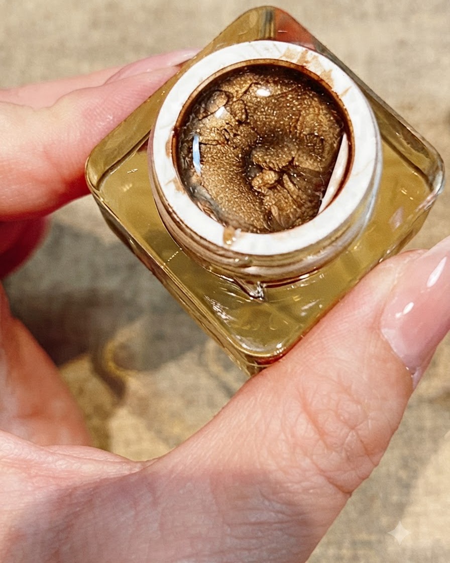 A tool placing a small sparkling rhinestone next to a finished painted rose on a nail.