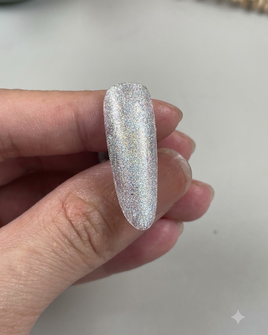 A close-up view of an almond-shaped nail showing a light blue shade layered over a sparkling base.