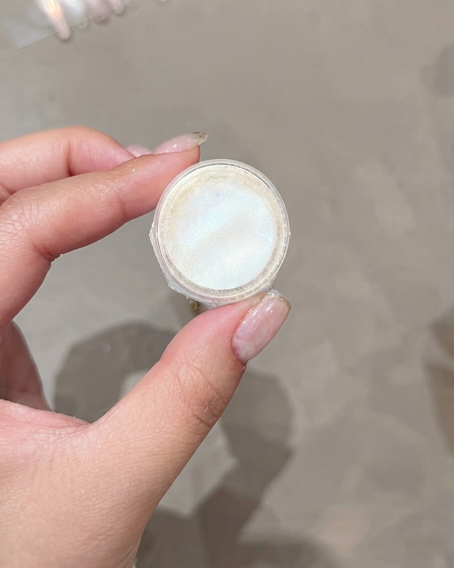 A jar of shimmering powder used for finishing effects.