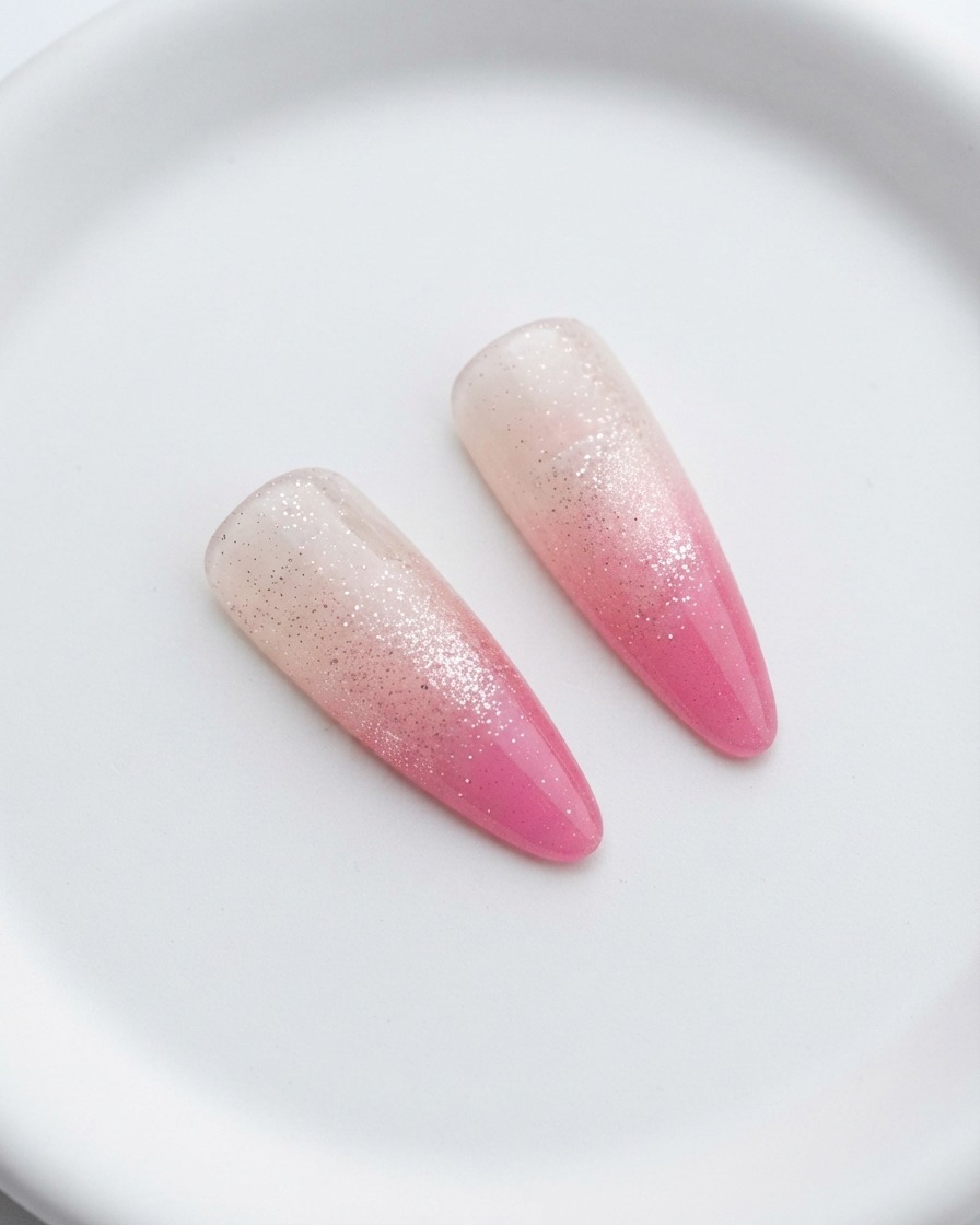 Nails curing under a UV lamp following the second pink layer.