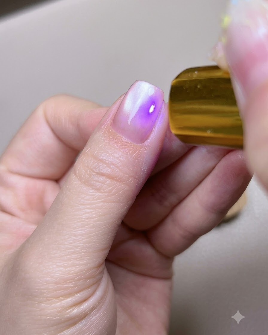 A thumbnail placed underneath a portable gold UV LED curing lamp.