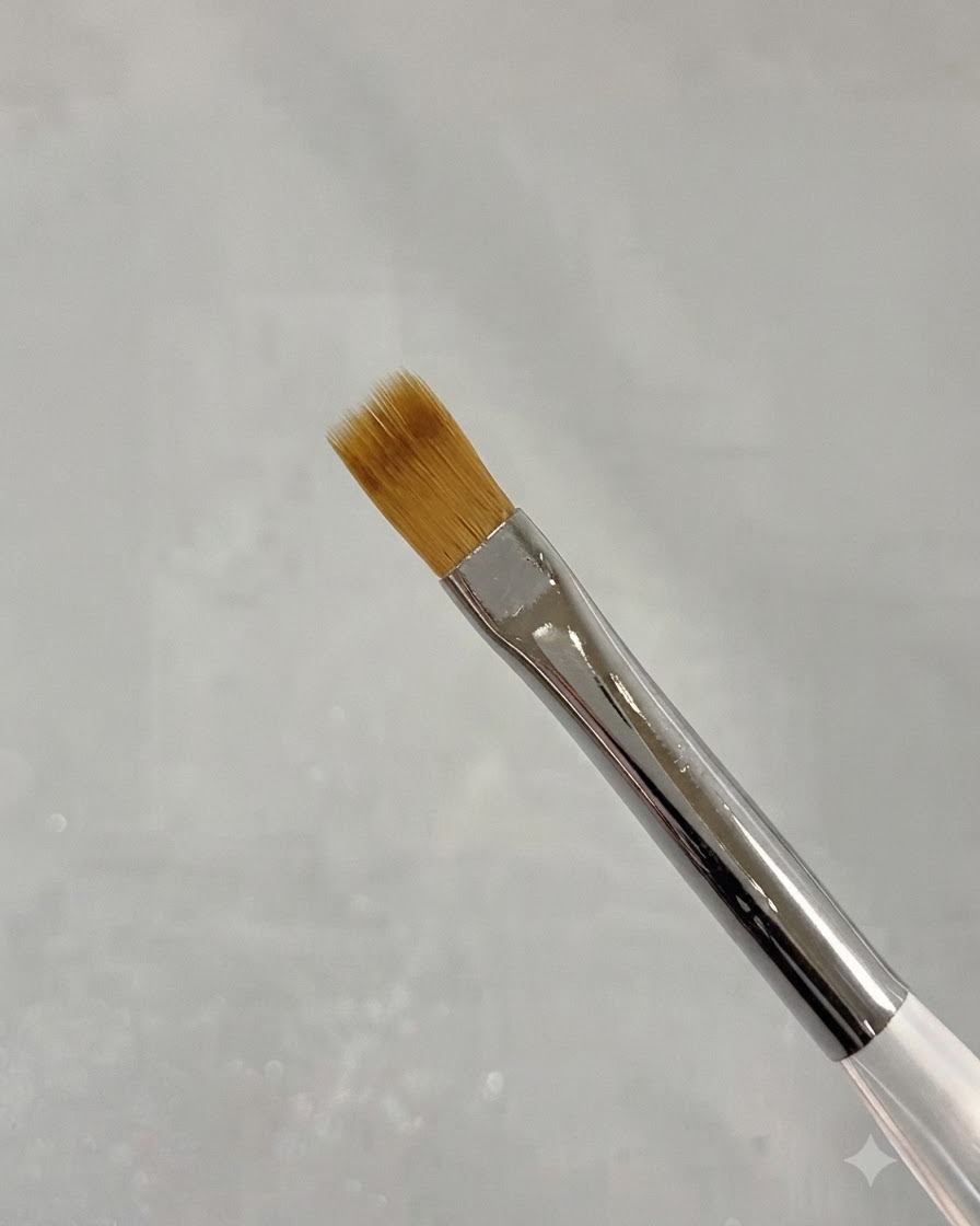 A close-up of a thin nail art sweeping brush with soft brown bristles.