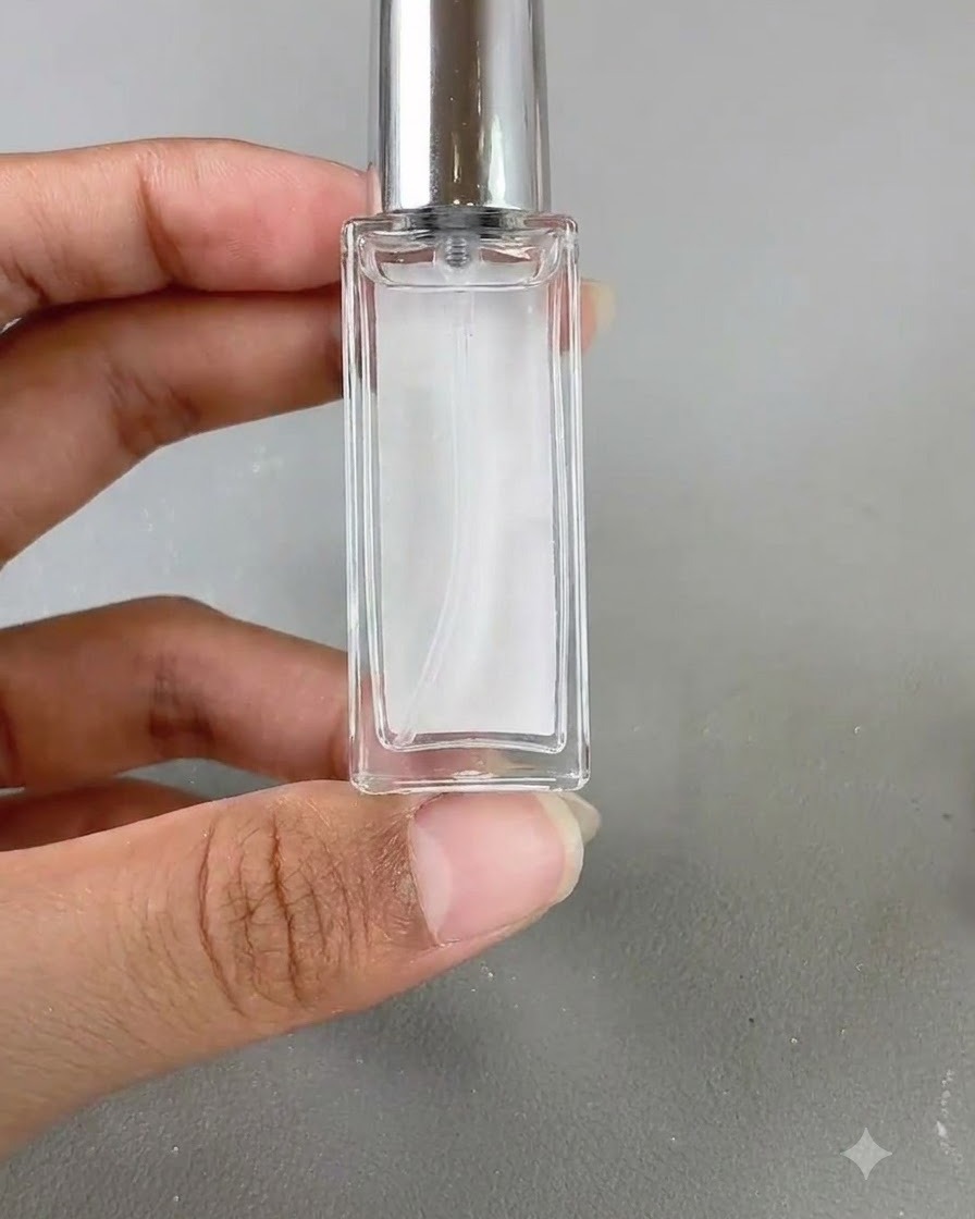 A small glass bottle of blooming liquid held up against a neutral background.