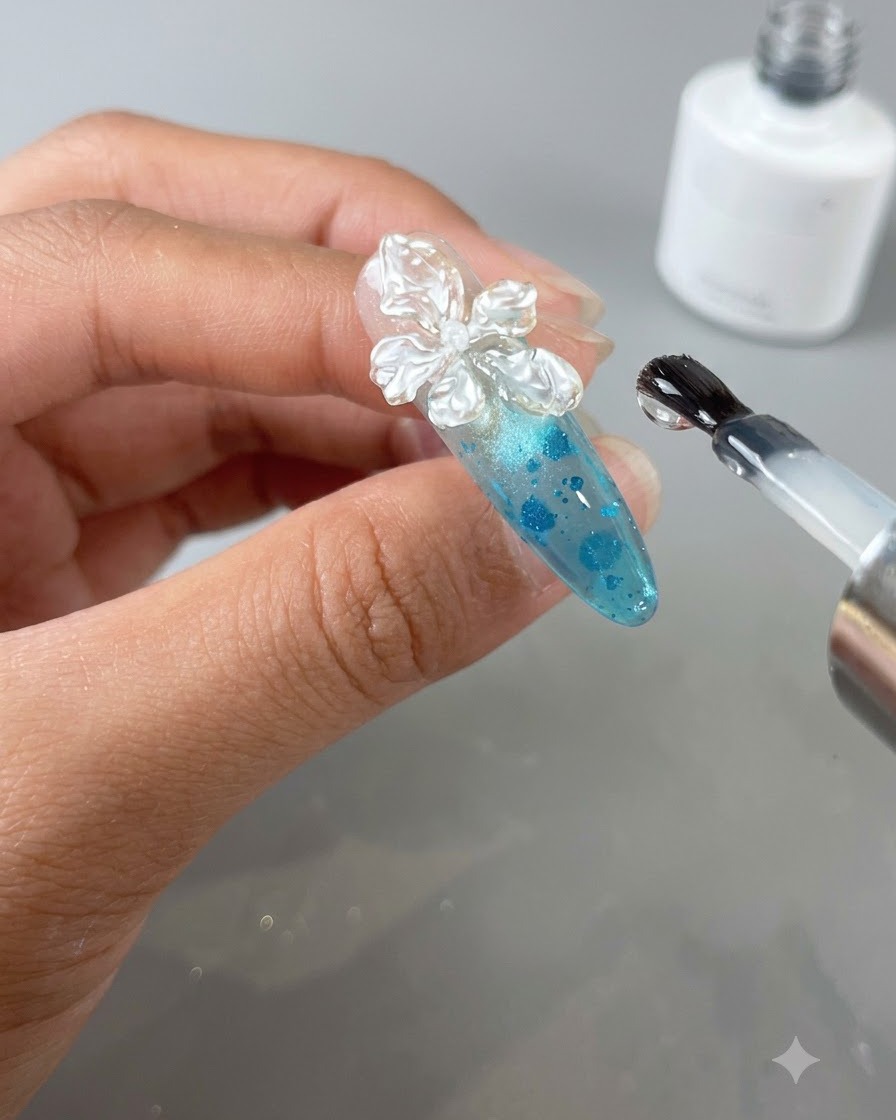 A close-up of a decorated nail being cured inside a UV/LED nail lamp.