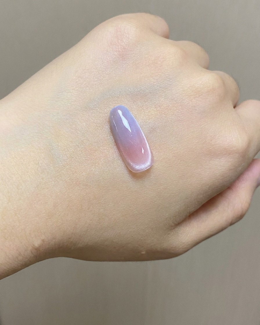 A sponge applying blue stamping gel onto the upper portion of a gradient nail tip.