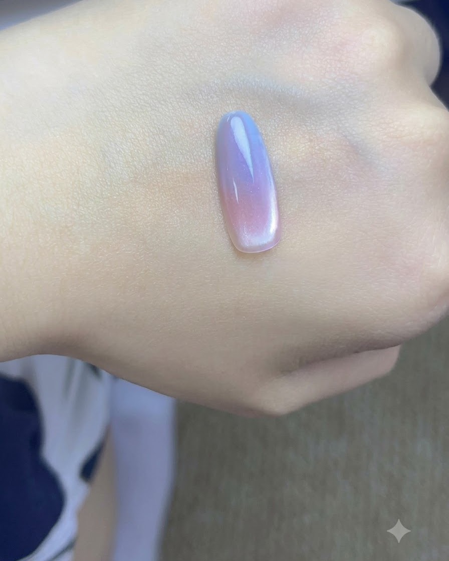 A small magnet held closely to the side of a painted nail tip to concentrate cat-eye particles.