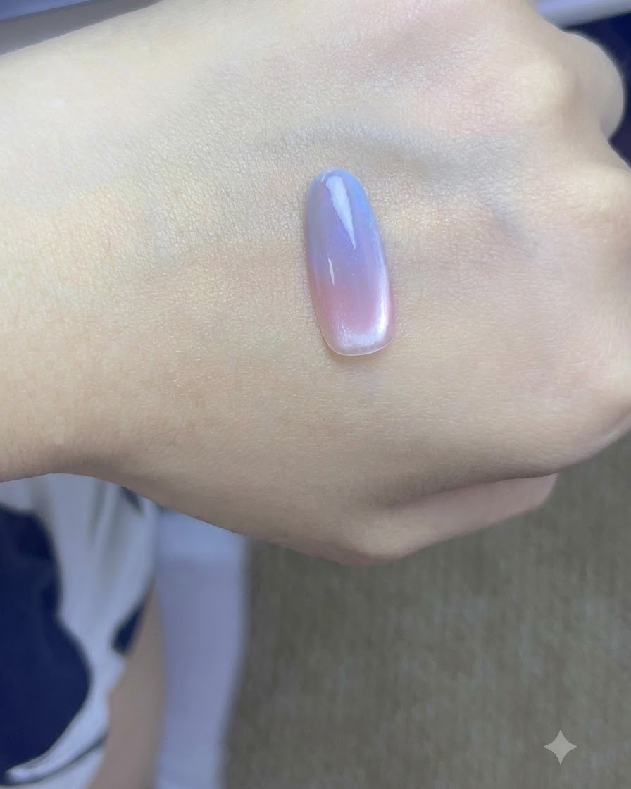 A hand with finished gradient cat eye nails curing under a professional UV nail lamp.