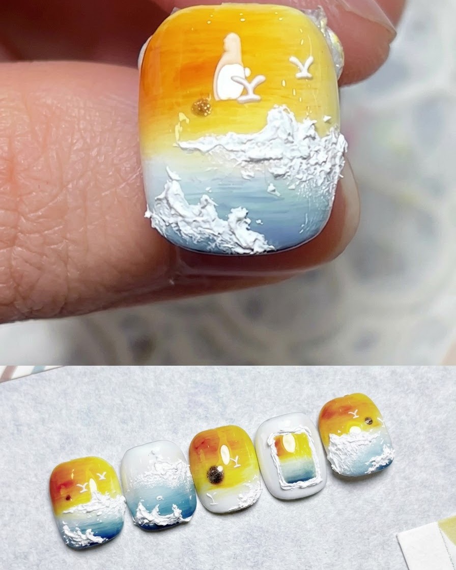 A brush applying top coat over a finished sunset gradient nail art design.