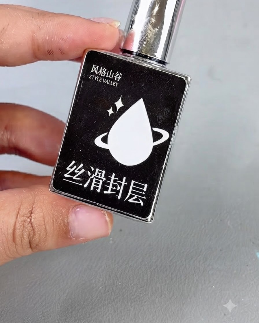 A black bottle with a silver cap and a white droplet icon labeled with text, representing smooth top coat gel.