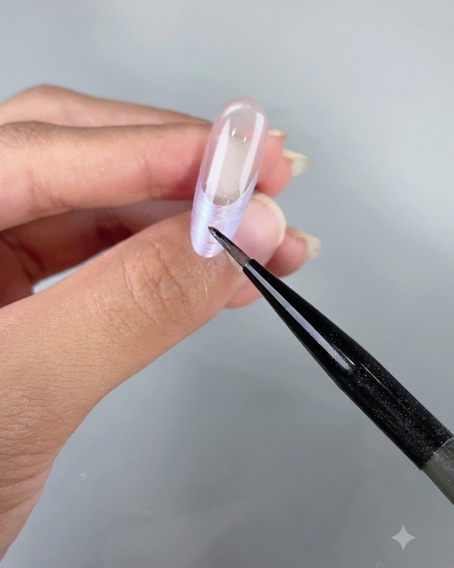 A fine detail tool placing small iridescent shell flakes along the French tip of a nail.
