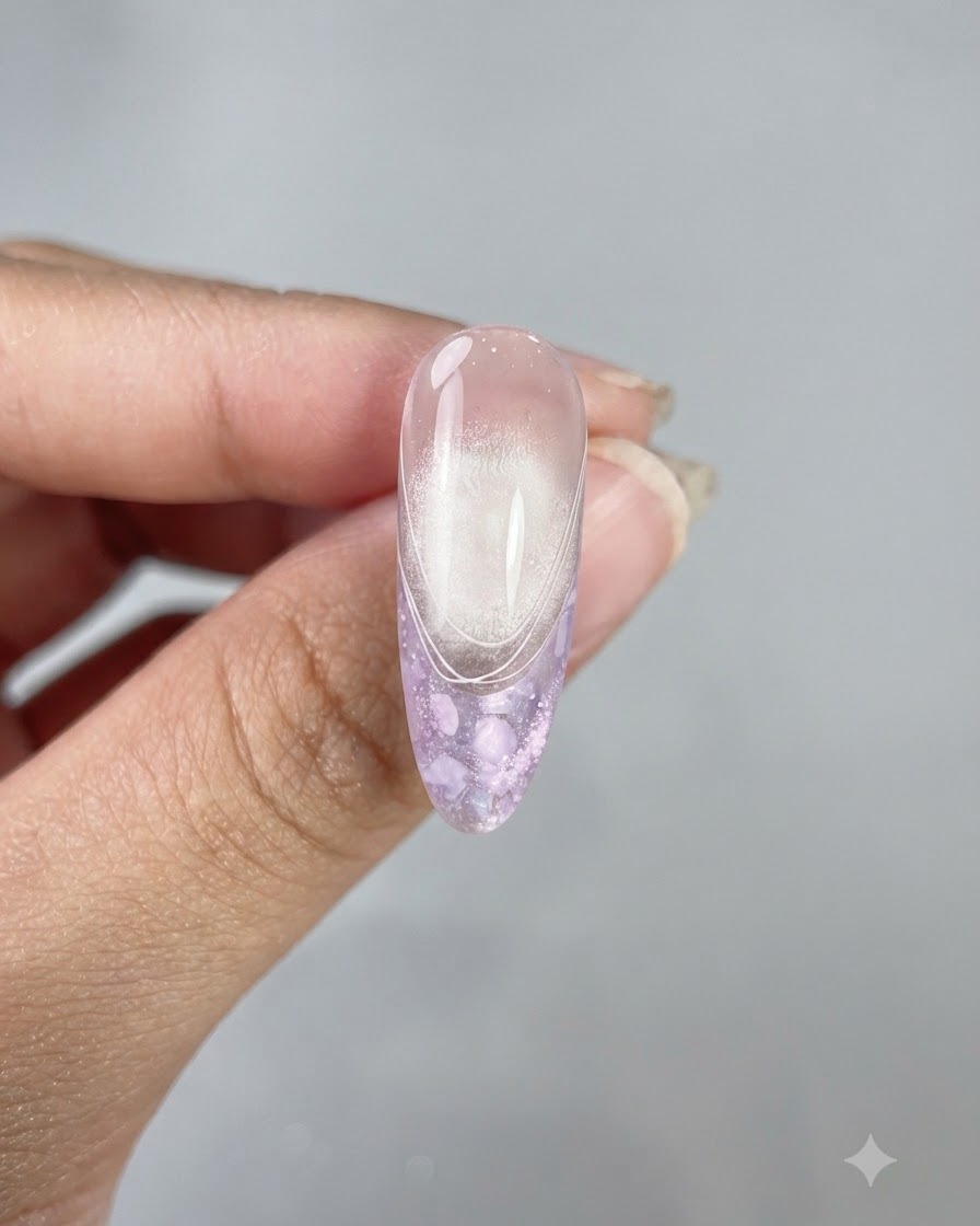 A finished long almond-shaped nail showcasing a glossy top coat, cat eye finish, and delicate white French lines.