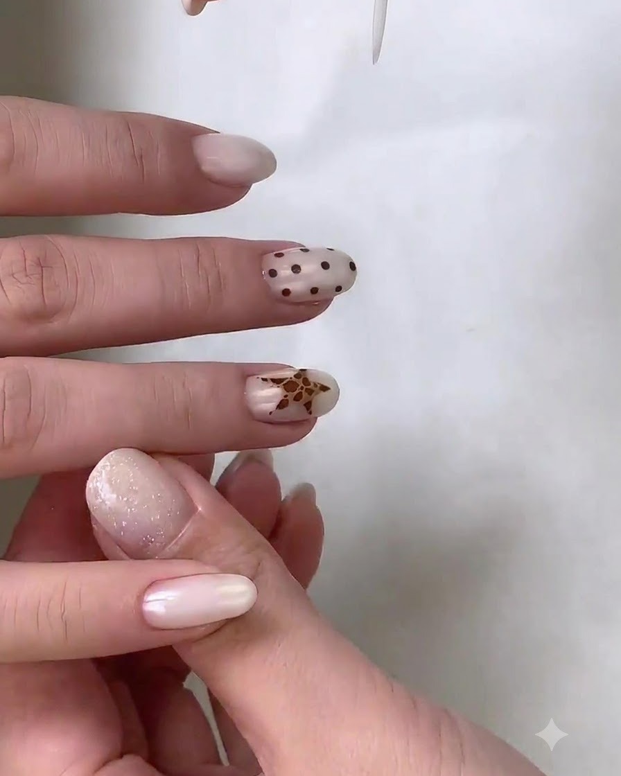 A fine liner brush adding intricate leopard print details inside a star-shaped nail art design.