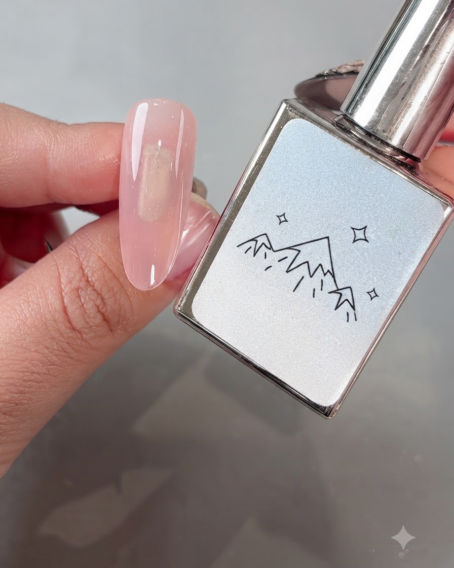 A brush applying White Boiling Water No. 2 cat-eye gel evenly onto a pink-based nail.