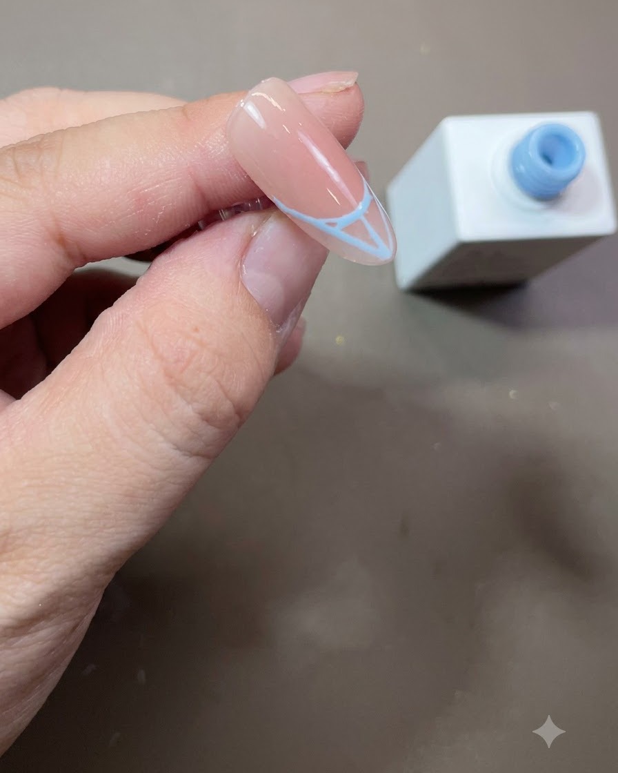 A completed blue French tip outline filled in solidly with blue gel polish on an almond-shaped nail.