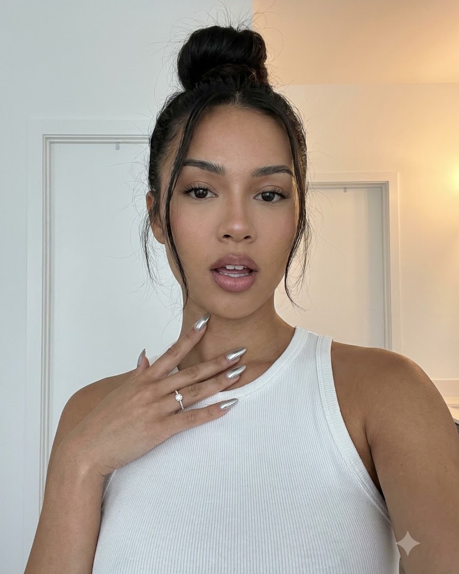 A hand positioned to show the side view profile of silver chrome manicured nails.