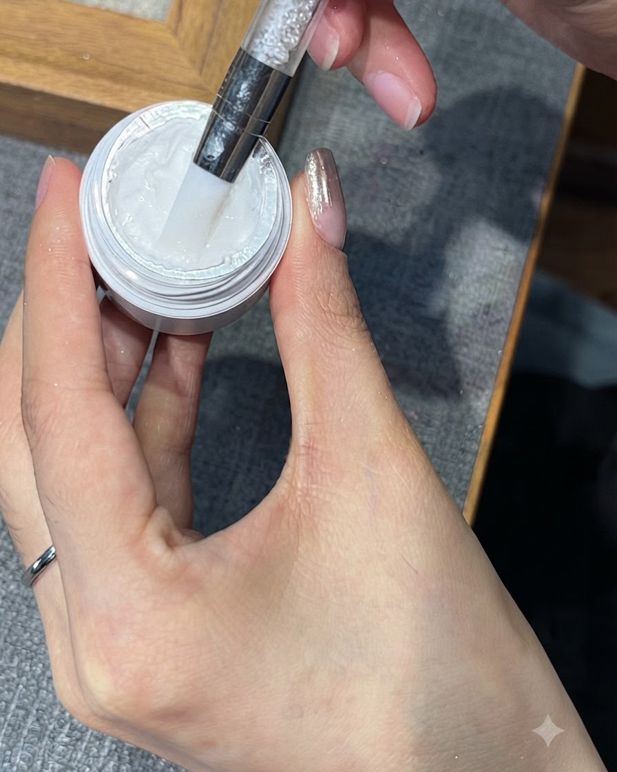 A tool taking a small amount of white stamping gel from its jar.