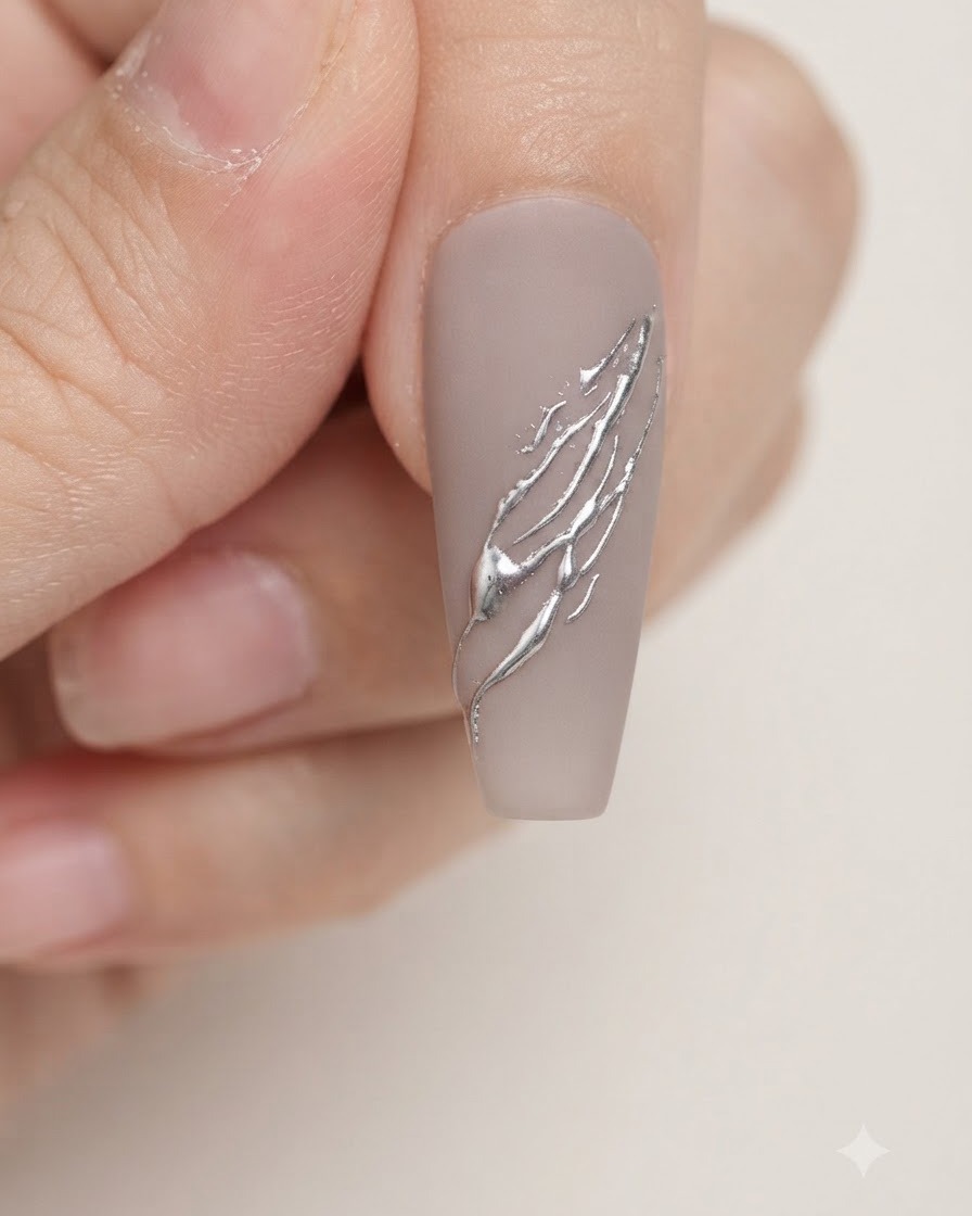 A soft makeup brush dusting excess metallic silver powder off a manicured nail.
