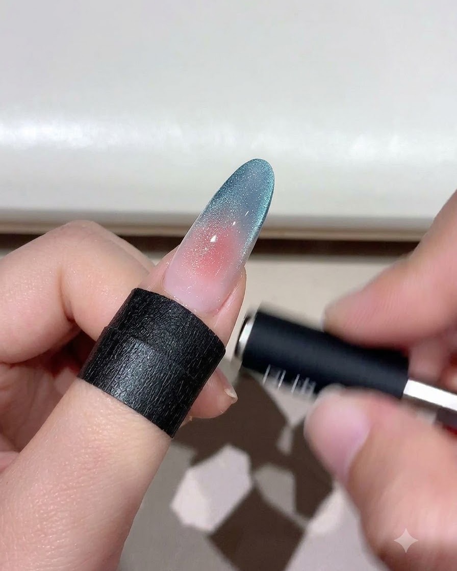 A magnetic tool hovering over a gradient cat eye nail to shape the shimmer particles.