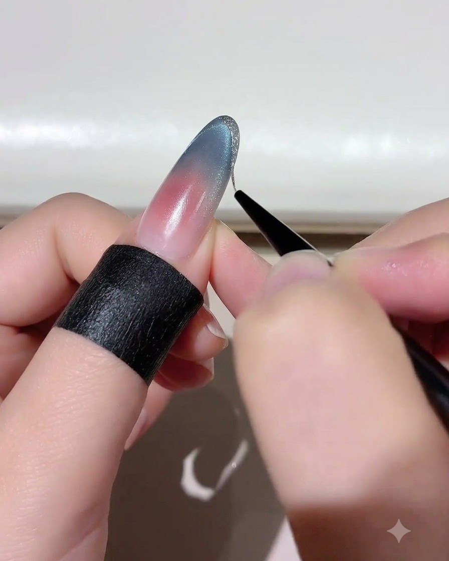 A fine liner brush applying platinum gold gel along the edge of a nail tip.