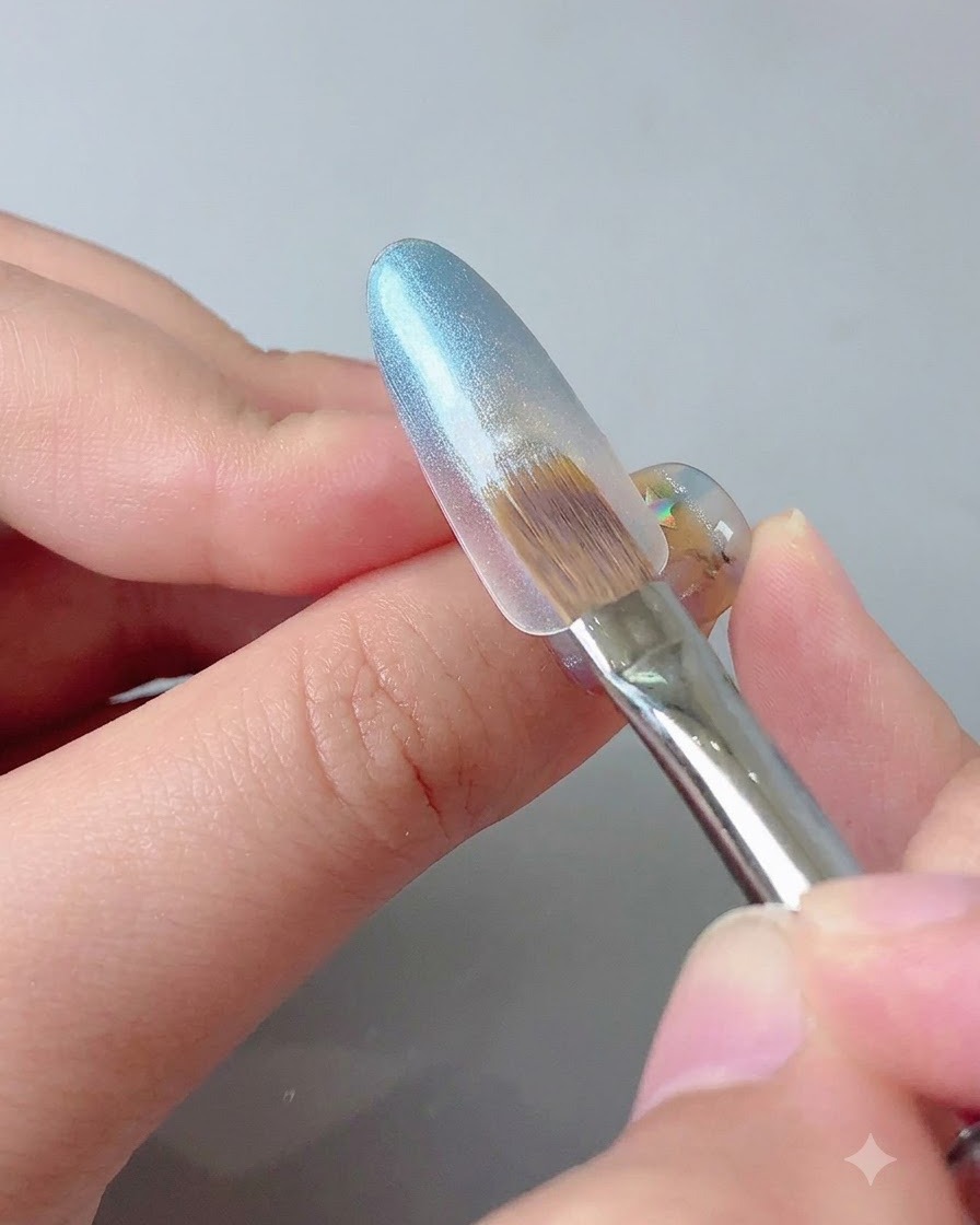 A magnetic tool held near a blue gel nail tip to concentrate the cat eye sparkle.