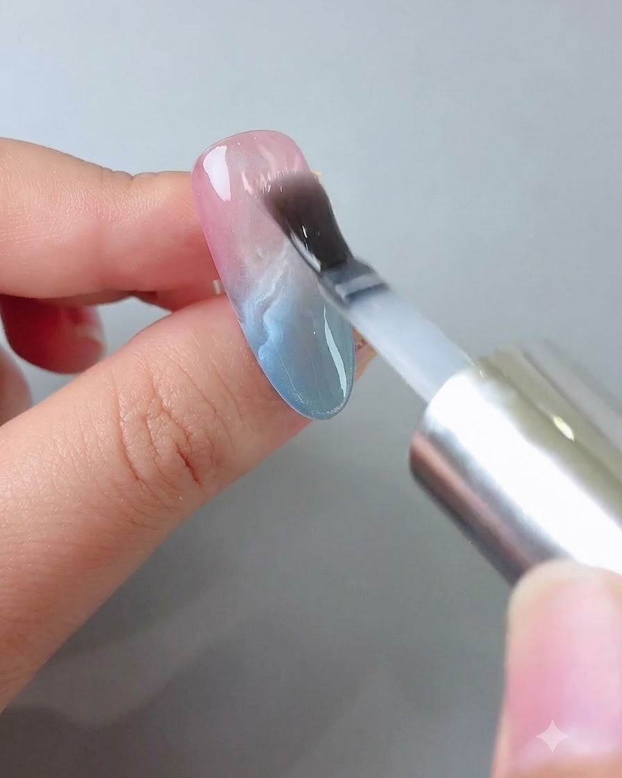 A brush applying a clear layer of builder gel smoothly over the decorated nail.