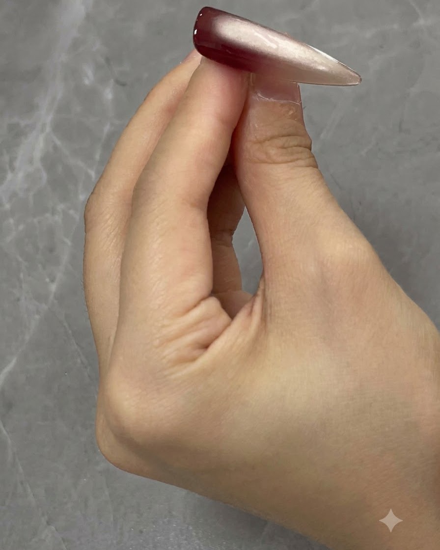 Applying a second coat of cat eye gel onto the nail surface.