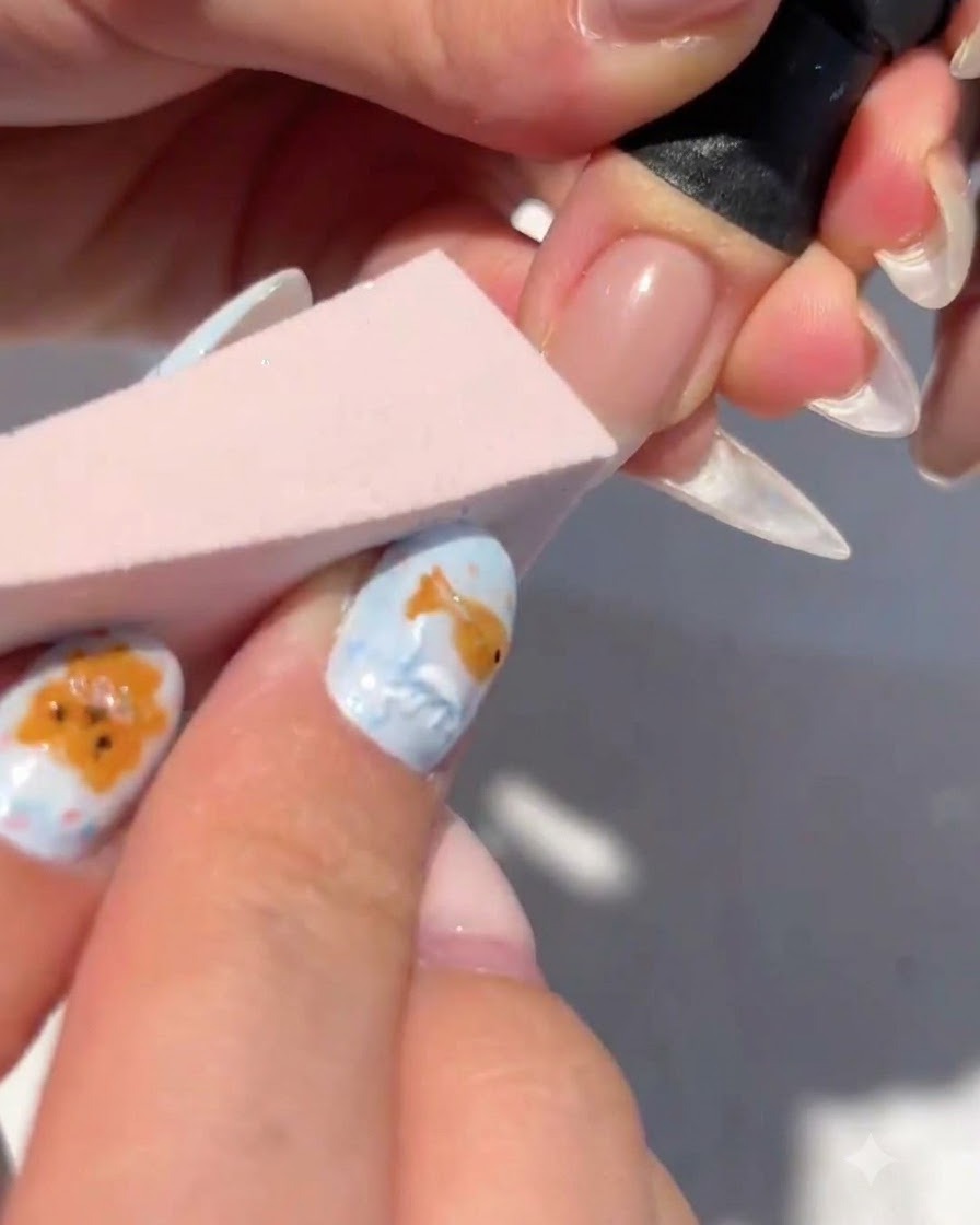 A makeup sponge dabbing white gel onto the tip of a nail to form a gradient.