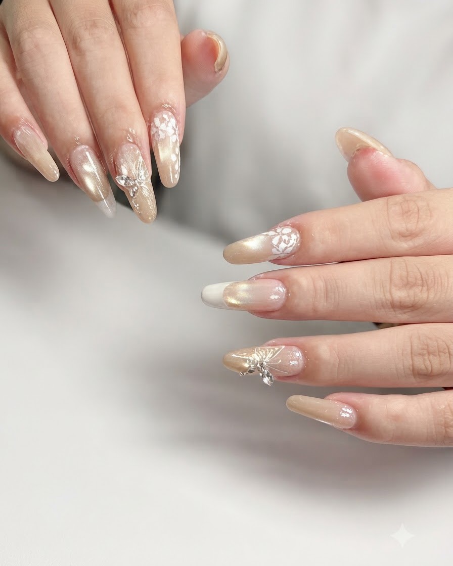 Macro shot of a ring finger nail featuring intricate white floral lace nail art over a nude gradient base.