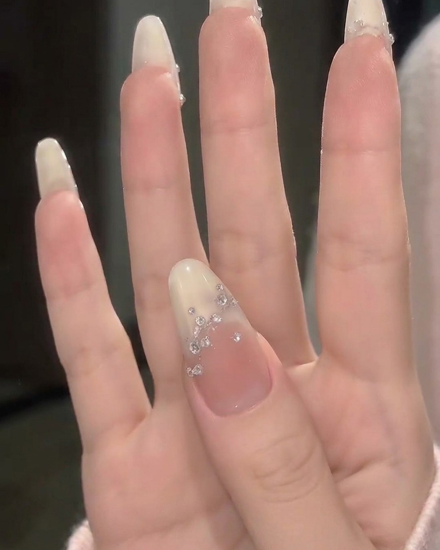 A side profile view of fingers showing the high-gloss shine and smooth curved surface of the finished manicure.