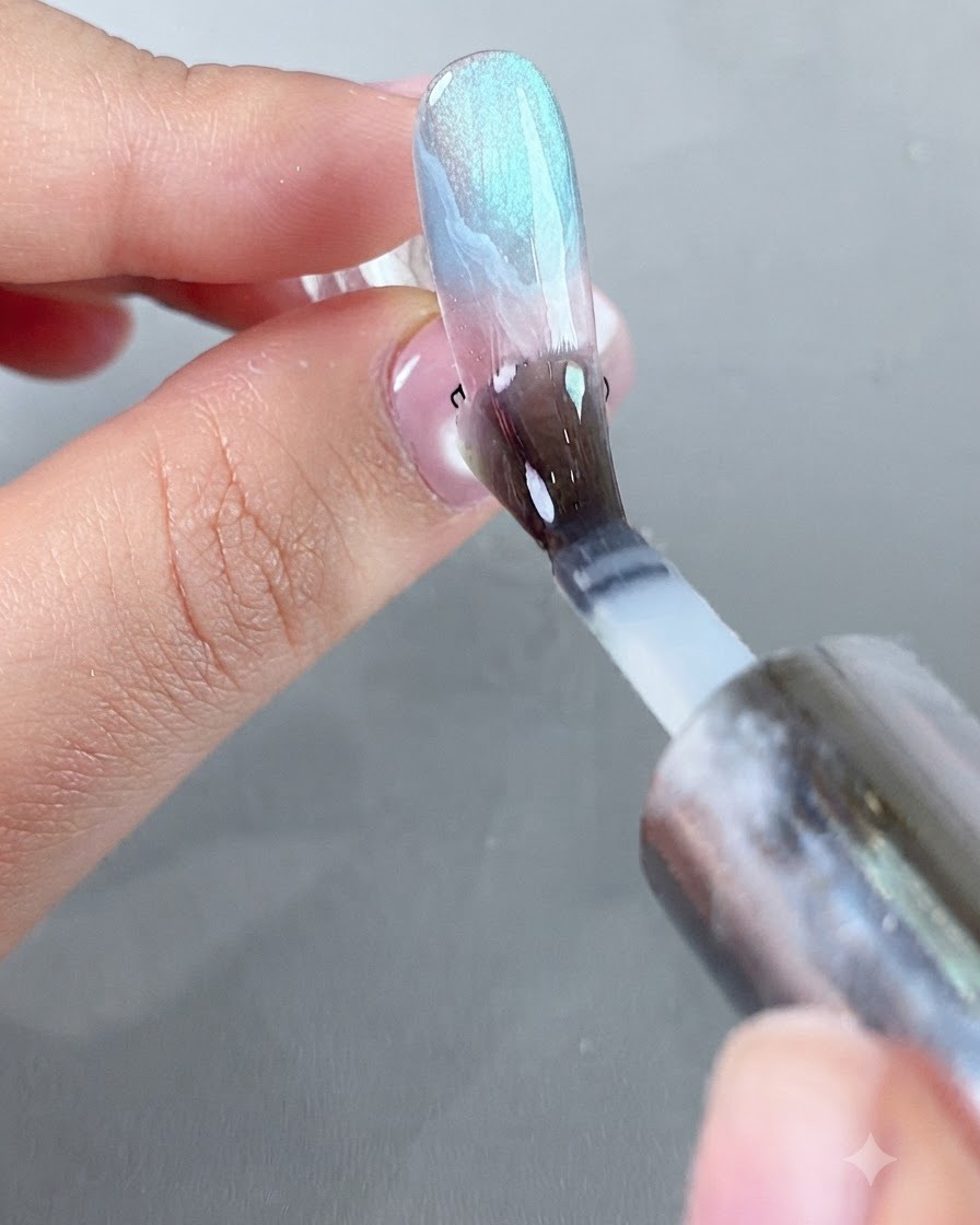 A brush applying a smooth coat of protective powder-isolating top coat over the decorated nail surface.