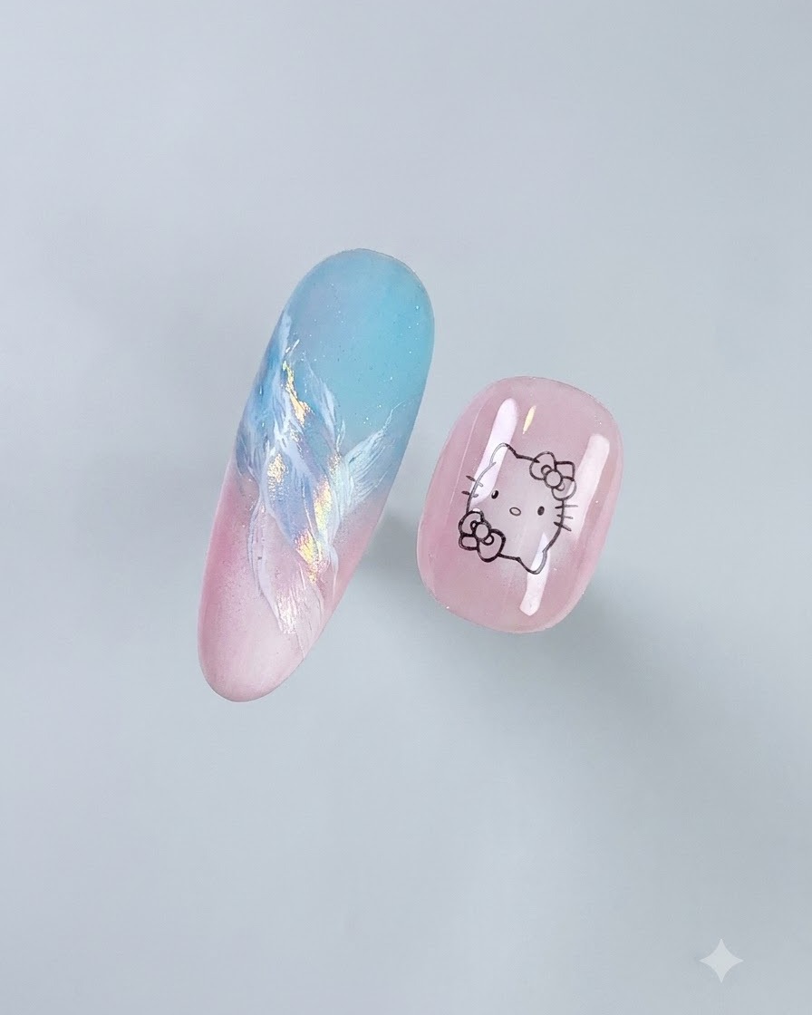 A close-up view of two decorated artificial nail tips resting against a light gray background showing a completed gradient and art design.