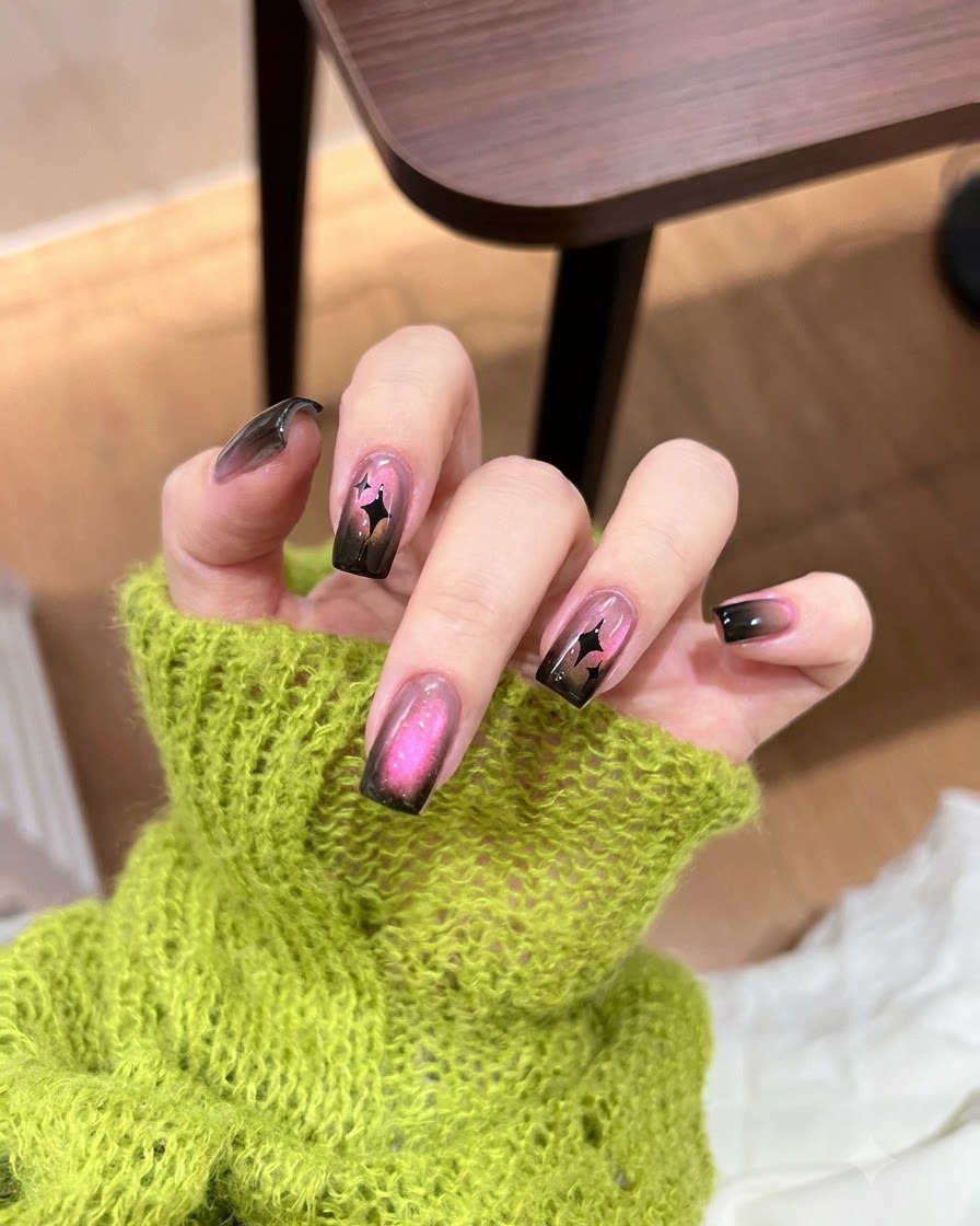 A small sponge dabbing black gel polish onto the tip of a nail.