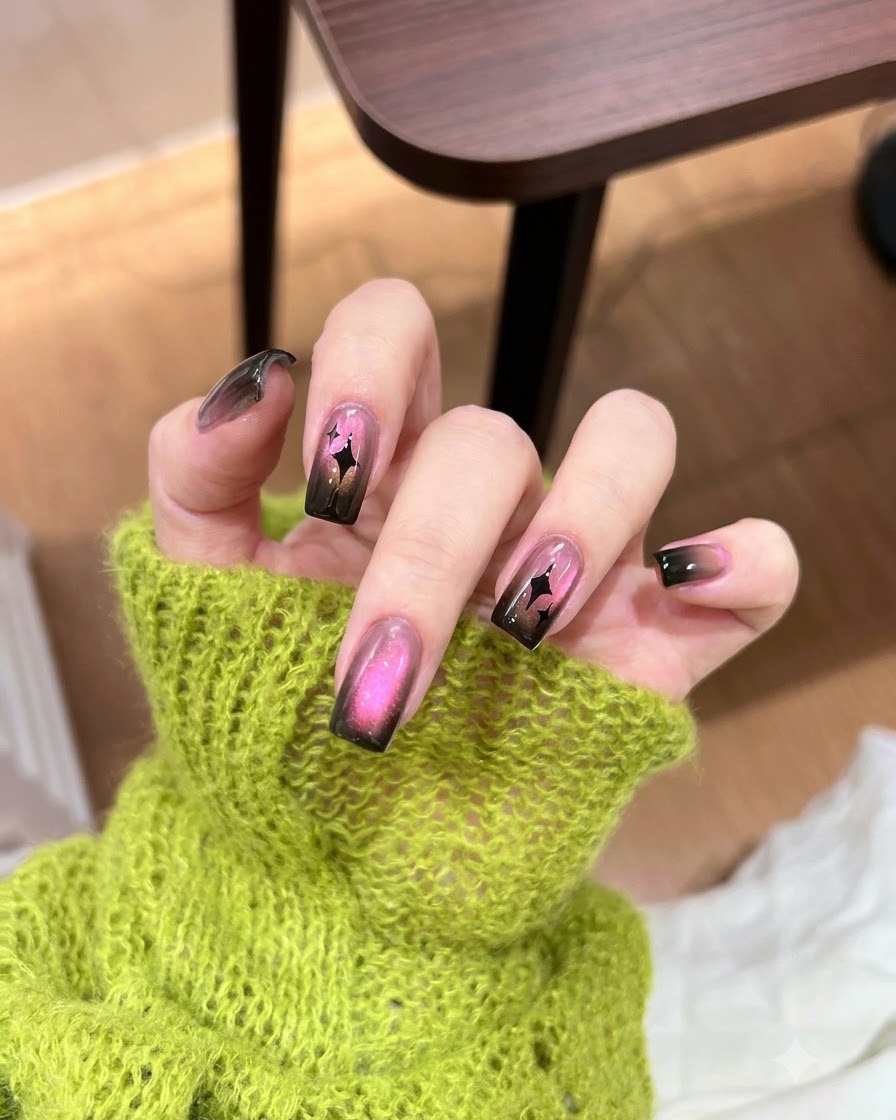 Applying a concentrated touch of dark black gel polish to the tip of a gradient nail.