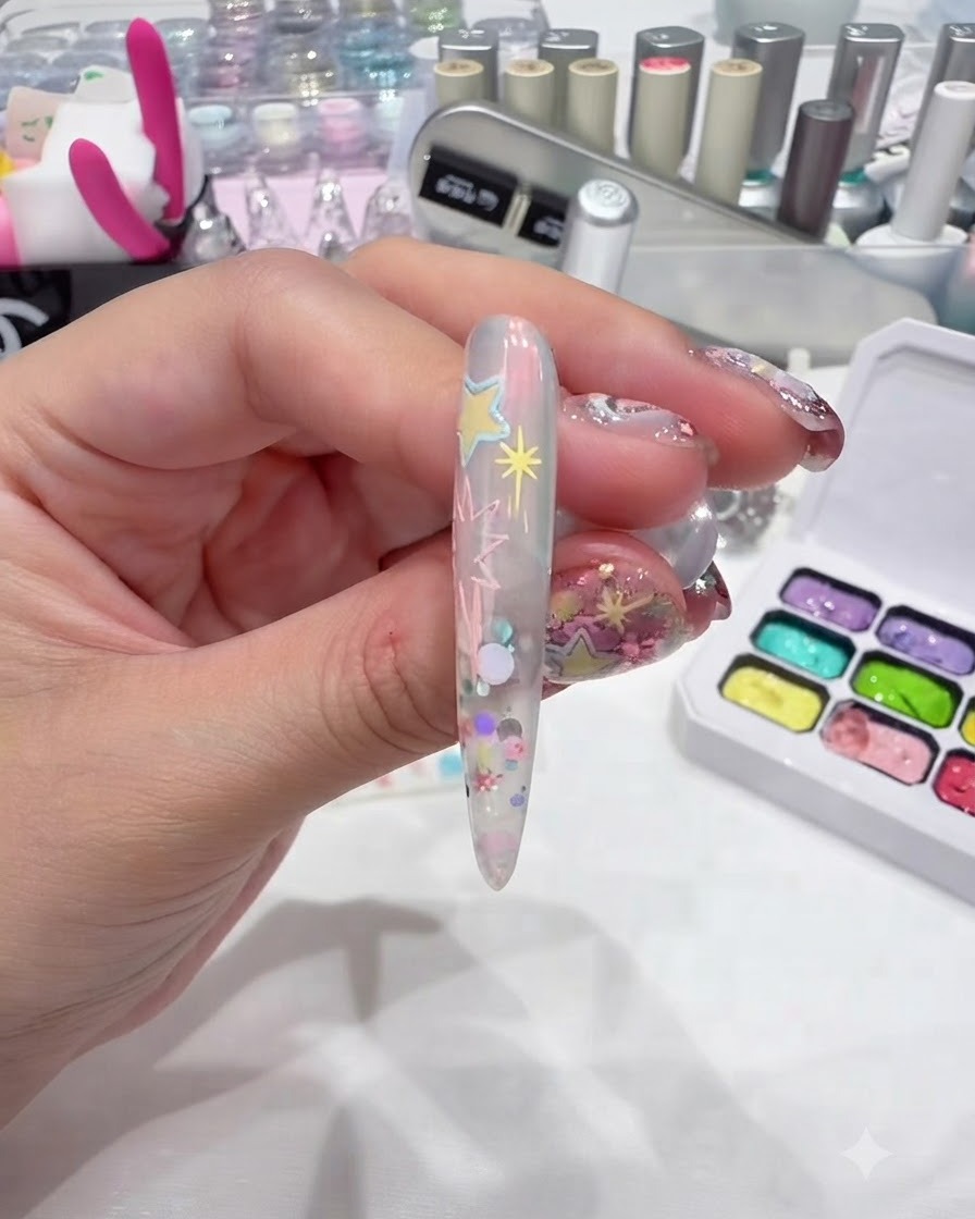 A liner brush drawing the outline of a small heart near the nail base.