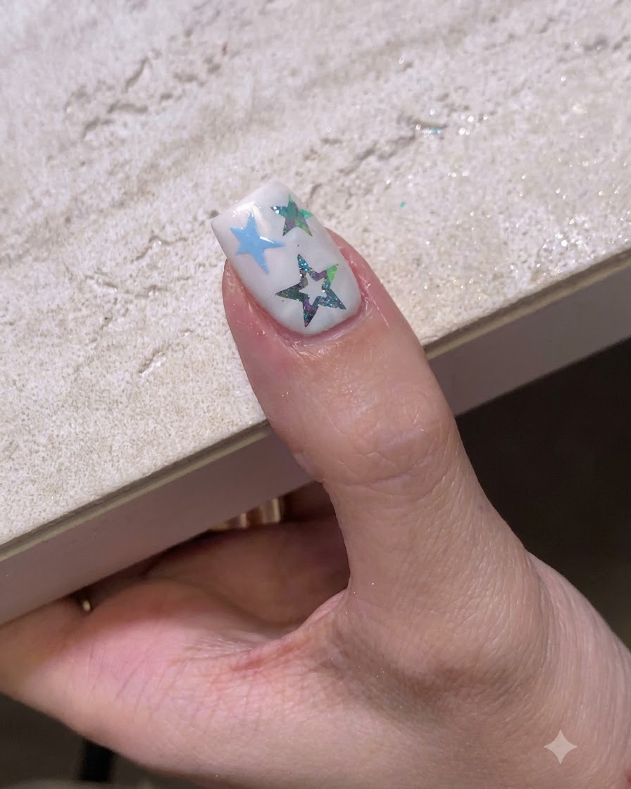 A decorated fingernail resting under a UV or LED nail lamp for curing.