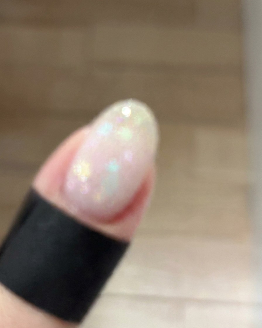 A small makeup sponge gently dabbing dusty pink gel onto the center of a manicured nail to create a soft blush gradient.