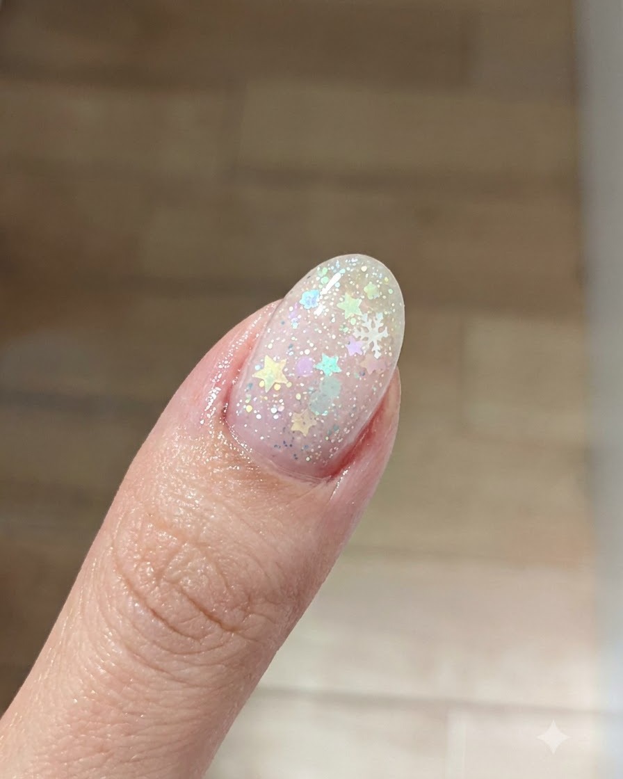 A close-up view of a dusty pink blush color being gently patted onto the center of the nail plate.