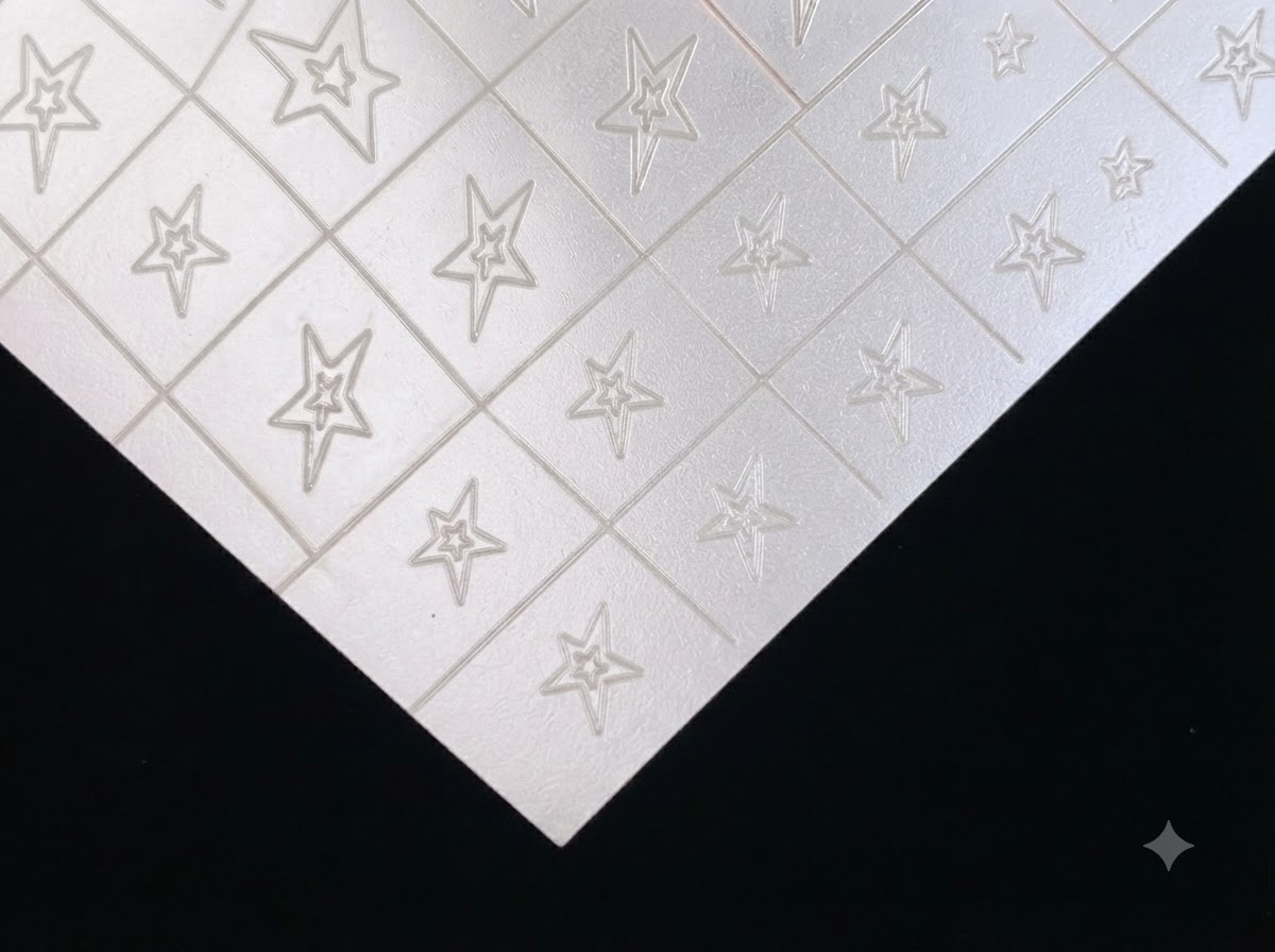 A sheet of clear and silver hollow star nail art stickers on a dark background.