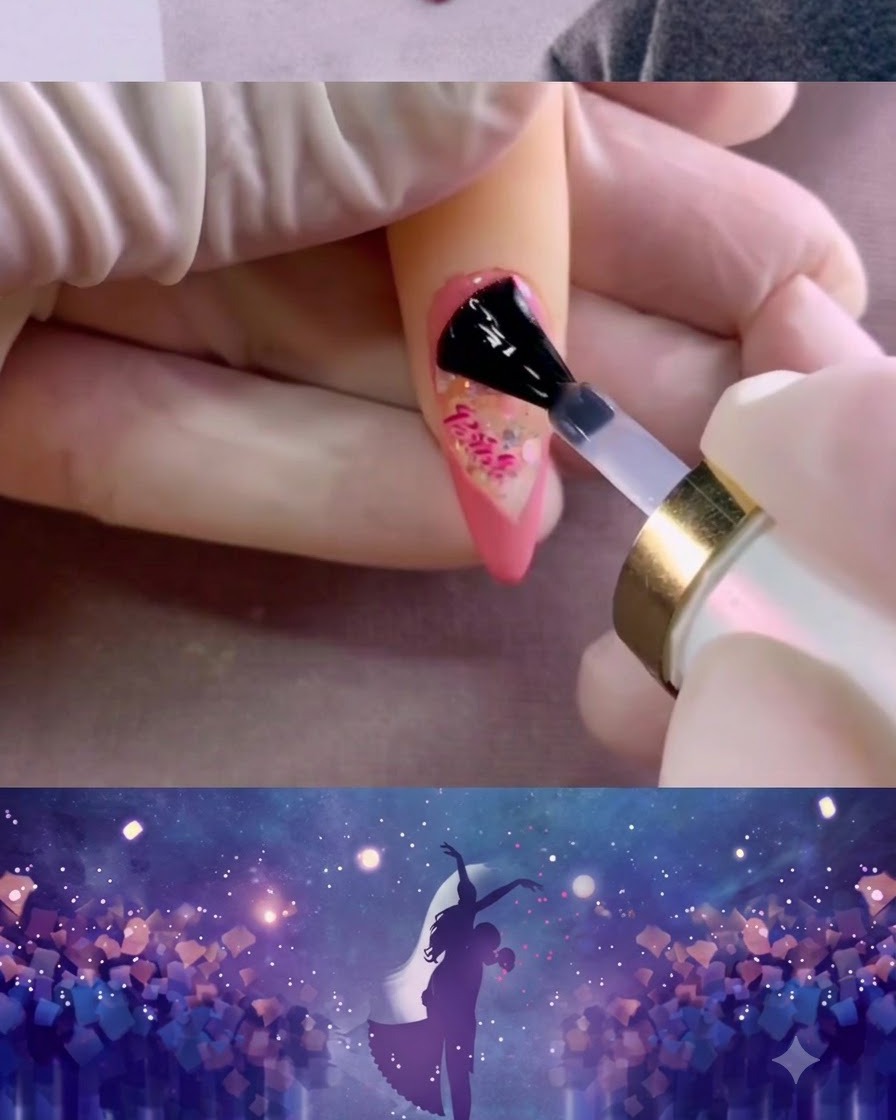 A nail brush spreading a layer of matte top coat across the pink-painted nail surface.