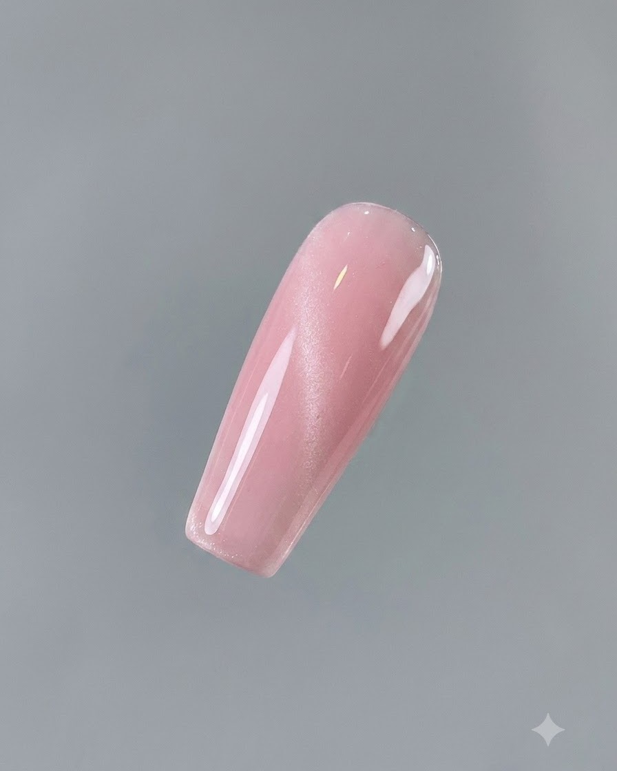 A close-up of a nail fully coated in a glossy pinkish Aqua Clear No. 2 cat eye gel.