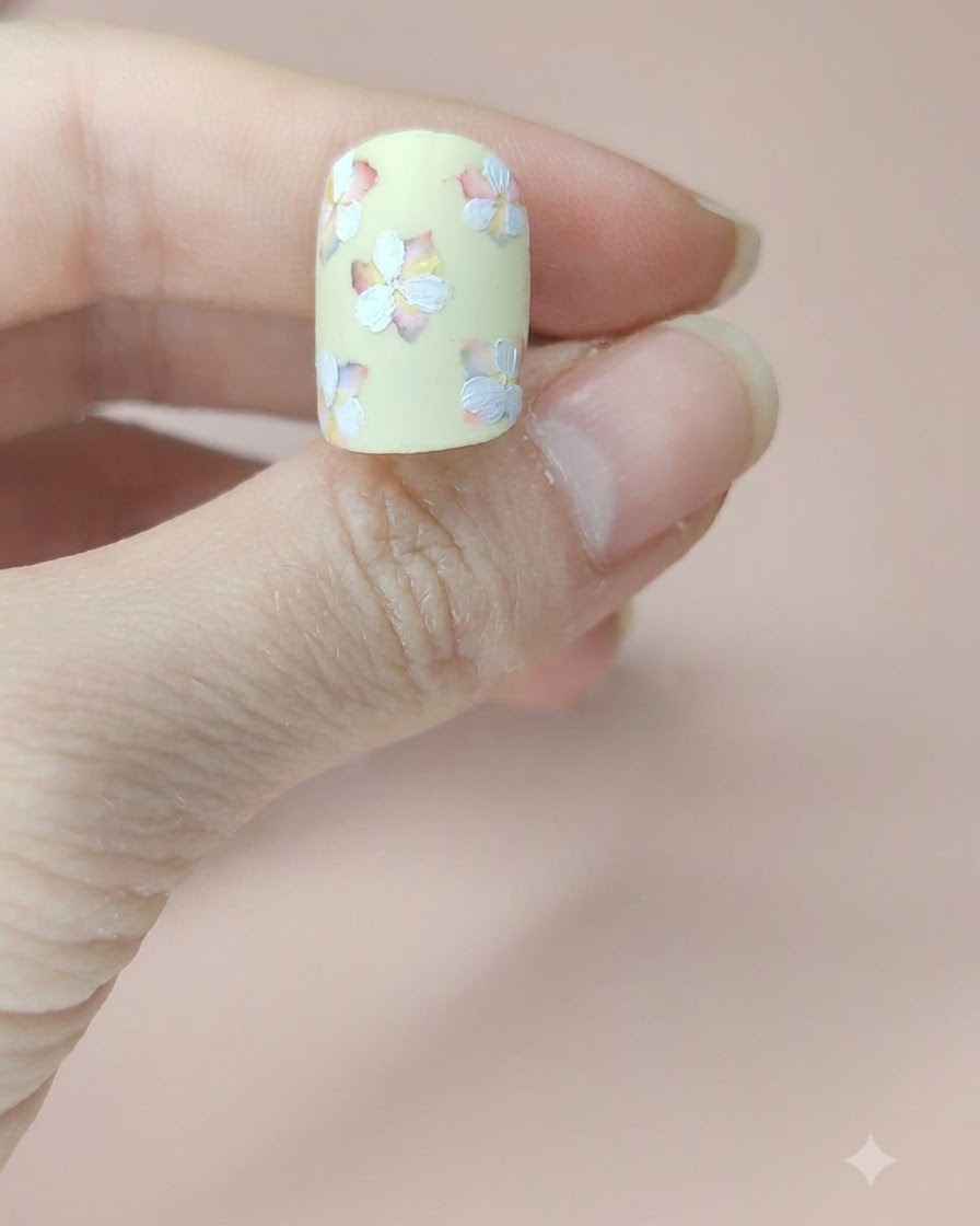 A close-up view of the nail showing all flowers with their second layer of white petals fully painted.